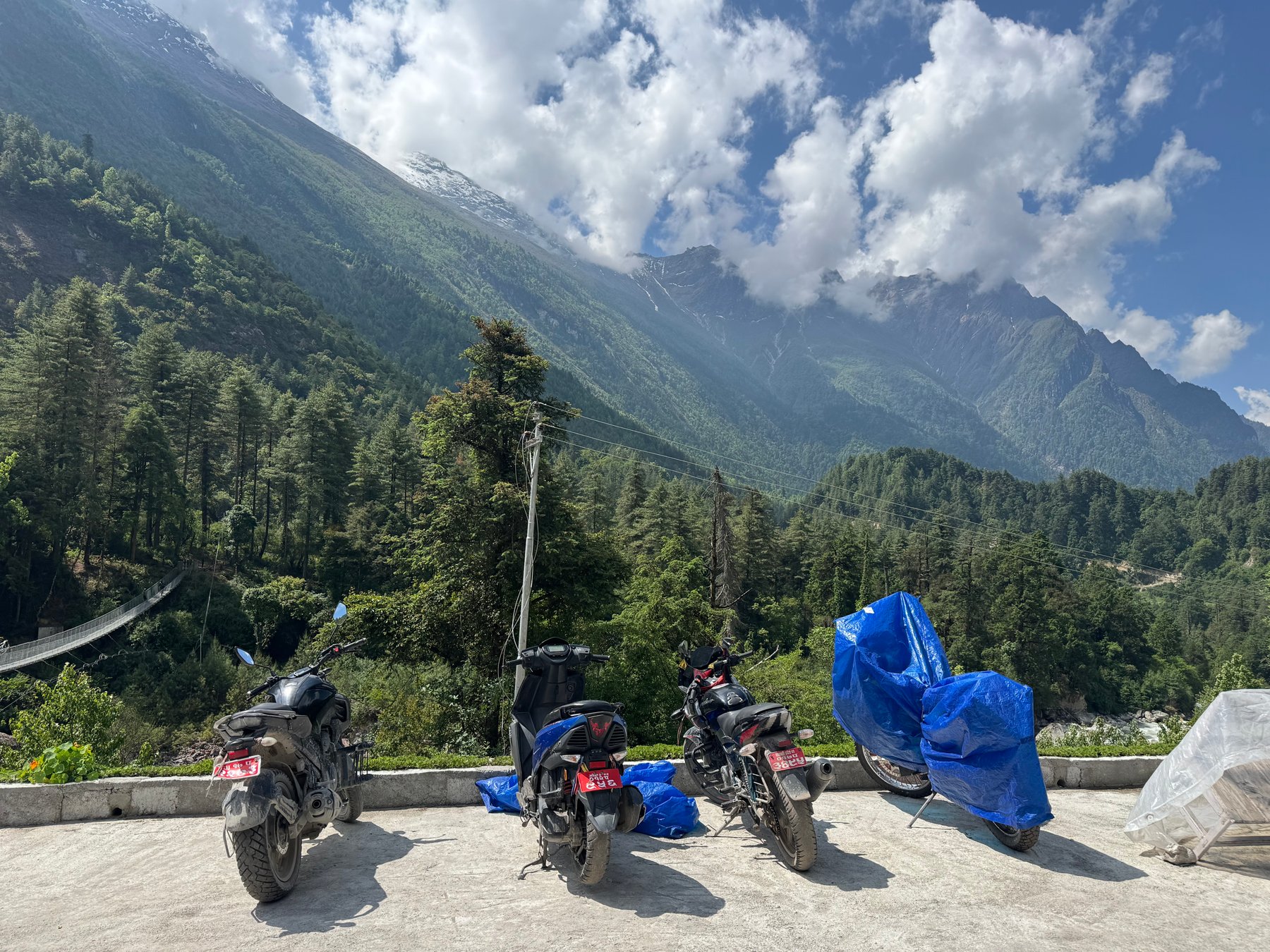 Motorbikes at the roadside below the mountains.